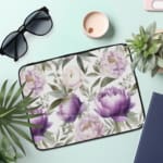 Elegant floral laptop sleeve with purple flowers and green leaves on a soft, light background. the laptop sleeve on the table