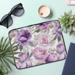 Infidu Elegant Floral Laptop Sleeve with purple and pink flowers, green leaves, and a soft white background, offering stylish laptop protection. the laptop sleeve on the table