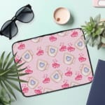 Infidu Light Pink Laptop Sleeve with Mug & Heart Print Design featuring small mugs with blue hearts and pink heart prints. the laptop sleeve on the table