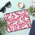 Infidu White Laptop Sleeve with a Large Pink Heart Design, featuring a cheerful pattern of pink hearts on a white background. the laptop sleeve on the table