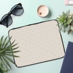 Infidu Light Dot Pattern Laptop Sleeve with off-white background and subtle dot design the laptop sleeve on the table