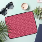 Infidu pink floral textured laptop sleeve with a delicate pattern and secure zip. the laptop sleeve on the table