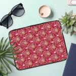 Infidu deep red laptop sleeve with pink and white heart pattern, featuring a zip closure for protection and style. the laptop sleeve on the table