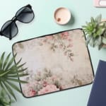 Infidu Soft Floral Pink & Beige Elegant Laptop Sleeve with delicate flowers in light pink, beige, and cream shades. the laptop sleeve on the table