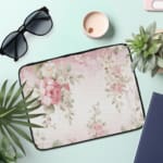 Infidu Soft Floral Pink & Beige Elegant Laptop Sleeve with delicate flowers in light pink, beige, and cream shades. the laptop sleeve on the table