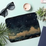 Infidu Night Sky Cosmic Cloud Stars Laptop Sleeve with dark cosmic design, featuring clouds, stars, and waves; protective fabric laptop sleeve with zip closure the laptop sleeve on the table