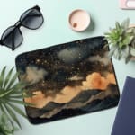 Infidu Night Sky Clouds Stars Laptop Sleeve with dark background, stars, and clouds design. the laptop sleeve on the table