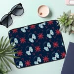 Dark blue laptop sleeve with white and red star patterns. the laptop sleeve on the table