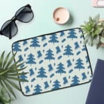 White laptop sleeve with a blue tree pattern for a nature-inspired look. the laptop sleeve on the table