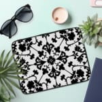 Infidu black and white mandala art laptop sleeve with intricate floral design. the laptop sleeve on the table