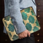 Infidu Vintage Floral Laptop Sleeve in blue, teal, and beige, with a classic floral pattern designed for laptop protection and style. the person holding the sleeve