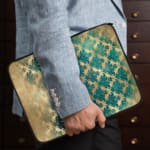 Infidu Rustic Beige Floral Blue Teal Laptop Sleeve with floral pattern in blue and teal tones on a faded beige background. the person holding the sleeve