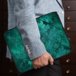 Infidu Dark Textured Teal-Green Laptop Sleeve with a smooth and elegant design. the person holding the sleeve