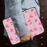 Infidu Cute Pink Heart Icon Laptop Sleeve with small pink heart patterns on a light pink background. the person holding the sleeve