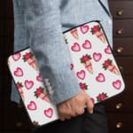 Infidu Romantic Heart & Floral Print Laptop Sleeve with pink hearts and flower bouquets on a white background. the person holding the sleeve