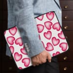 Infidu White Laptop Sleeve with a Large Pink Heart Design, featuring a cheerful pattern of pink hearts on a white background. the person holding the sleeve