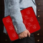 Infidu Bright Red Laptop Sleeve with White Heart and Teddy Bear Outline Pattern the person holding the sleeve