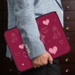 Infidu Romantic Dark Pink Heart Design Laptop Sleeve with intricate heart patterns and a couple of illustrations. the person holding the sleeve