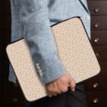 Infidu Simple Light-Colored Pattern Laptop Sleeve with subtle design and zip closure. the person holding the sleeve