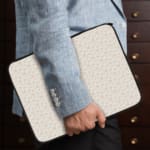 Infidu Light Dot Pattern Laptop Sleeve with off-white background and subtle dot design the person holding the sleeve