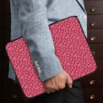 Infidu pink floral textured laptop sleeve with a delicate pattern and secure zip. the person holding the sleeve