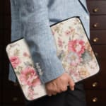 Vibrant pink floral laptop sleeve with large flowers, smaller blooms, and green leaves, offering stylish and elegant protection for your laptop. the person holding the sleeve