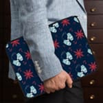 Dark blue laptop sleeve with white and red star patterns. the person holding the sleeve