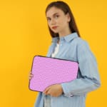 Light purple laptop sleeve with white triangle pattern, designed for a modern and minimalist look. the person holding the sleeve