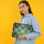 Infidu Elegant Dark Teal Floral Laptop Sleeve with beige and silver floral pattern on a dark teal background. the person holding the sleeve