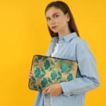 Infidu Beige Floral Design Laptop Sleeve with blue and teal flowers on a beige background. the person holding the sleeve