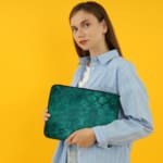 Infidu dark green laptop sleeve with textured pattern design the person holding the sleeve