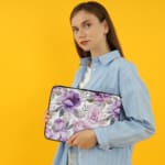 Infidu Elegant Floral Laptop Sleeve with purple and pink flowers, green leaves, and a soft white background, offering stylish laptop protection. the person holding the sleeve