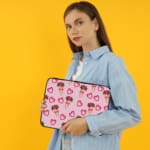 Infidu Romantic Heart & Floral Print Laptop Sleeve with pink hearts and flower bouquets on a white background. the person holding the sleeve