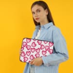 Infidu White Laptop Sleeve with a Large Pink Heart Design, featuring a cheerful pattern of pink hearts on a white background. the person holding the sleeve