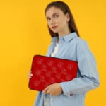 Infidu Bright Red Laptop Sleeve with White Heart and Teddy Bear Outline Pattern the person holding the sleeve