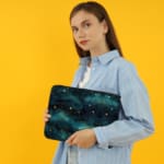 Infidu Night Sky Cosmic Cloud Stars Laptop Sleeve with dark cosmic design, featuring clouds, stars, and waves; protective fabric laptop sleeve with zip closure the person holding the sleeve