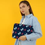 Dark blue laptop sleeve with white and red star patterns. the person holding the sleeve