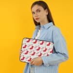 Infidu Christmas laptop sleeve with red stockings and holly berries on a white background, adding a festive touch for the holidays. the person holding the sleeve