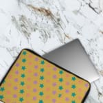 Infidu Green and Pink Star Pattern Laptop Sleeve with small green and pink stars on a light green background, displayed on a desk. The laptop sleeve covers the laptop