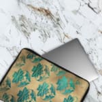 Infidu Beige Floral Design Laptop Sleeve with blue and teal flowers on a beige background. The laptop sleeve covers the laptop