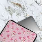 Infidu Cute Pink Heart Icon Laptop Sleeve with small pink heart patterns on a light pink background. The laptop sleeve covers the laptop