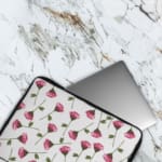 Infidu Floral Pink & Green Laptop Sleeve with pink flowers and green stems on a white background, offering protection and style. The laptop sleeve covers the laptop