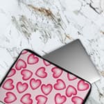 Infidu Pink Heart Pattern Laptop Sleeve with a playful design of large, evenly spaced pink hearts on a light pink background. The laptop sleeve covers the laptop