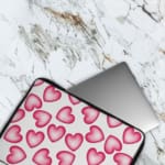 Infidu White Laptop Sleeve with a Large Pink Heart Design, featuring a cheerful pattern of pink hearts on a white background. The laptop sleeve covers the laptop