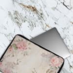 Elegant soft pink floral vintage laptop sleeve with light pink roses and green leaves on a pale background, designed for laptop protection. The laptop sleeve covers the laptop