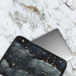 Rainy night sky laptop sleeve with stars, clouds, and a dark blue background. The laptop sleeve covers the laptop