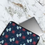 Dark blue laptop sleeve with white and red star patterns. The laptop sleeve covers the laptop