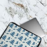 White laptop sleeve with a blue tree pattern for a nature-inspired look. The laptop sleeve covers the laptop