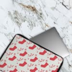 Infidu Christmas laptop sleeve with red stockings and holly berries on a white background, adding a festive touch for the holidays. The laptop sleeve covers the laptop