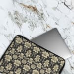 Black laptop sleeve with white floral pattern, detailed and symmetrical, for a bold and classic look. The laptop sleeve covers the laptop